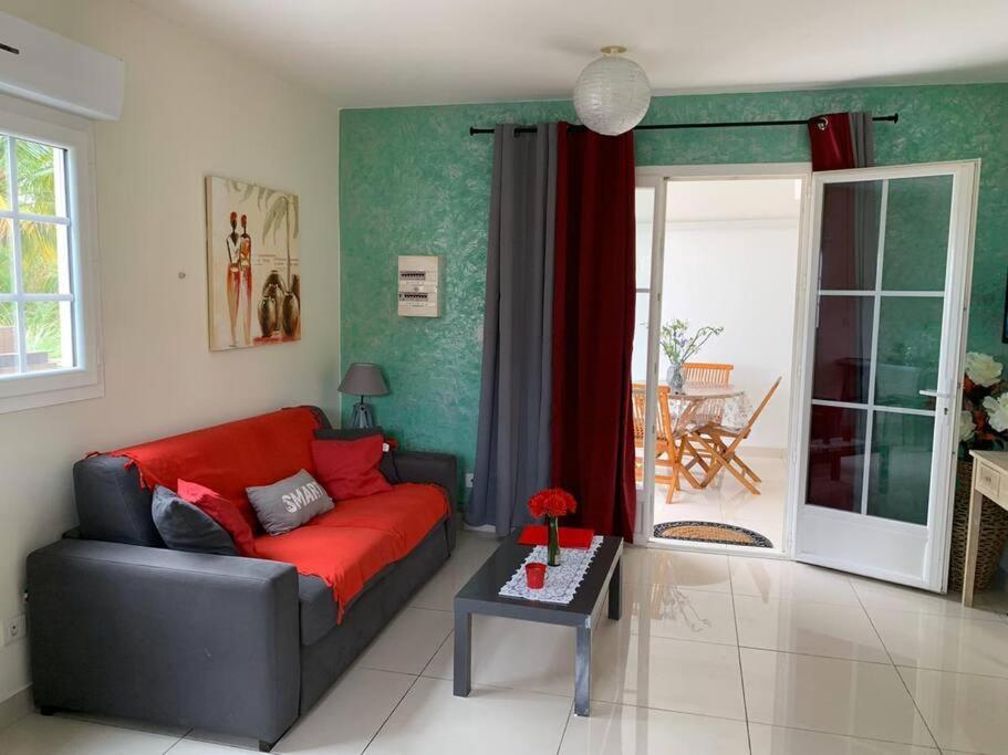 un soggiorno con divano rosso e tavolo di Superbe appartement pour 6 personnes à Trinité a La Trinité