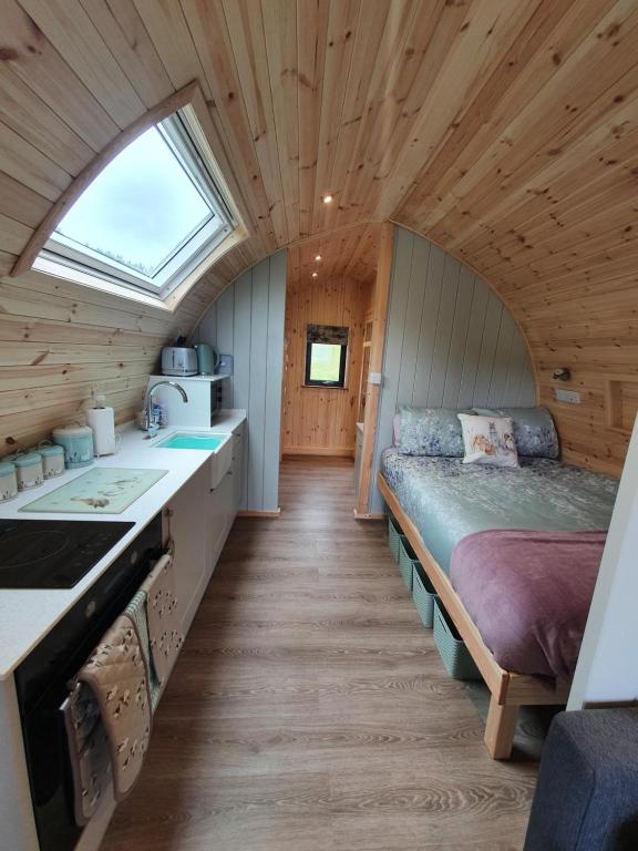 オークニー諸島にあるLilly's Lodges Orkney Robin Lodgeのベッド付きの部屋、キャビン内のキッチンを提供しています。