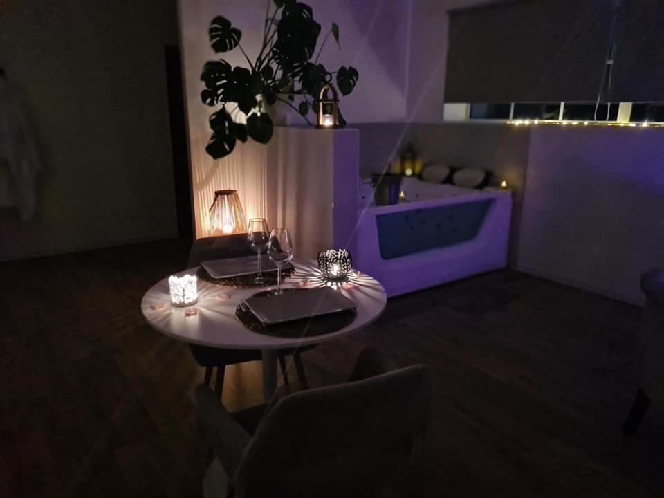 una mesa en una habitación con iluminación púrpura en L escapade amoureuse, en Bournezeau