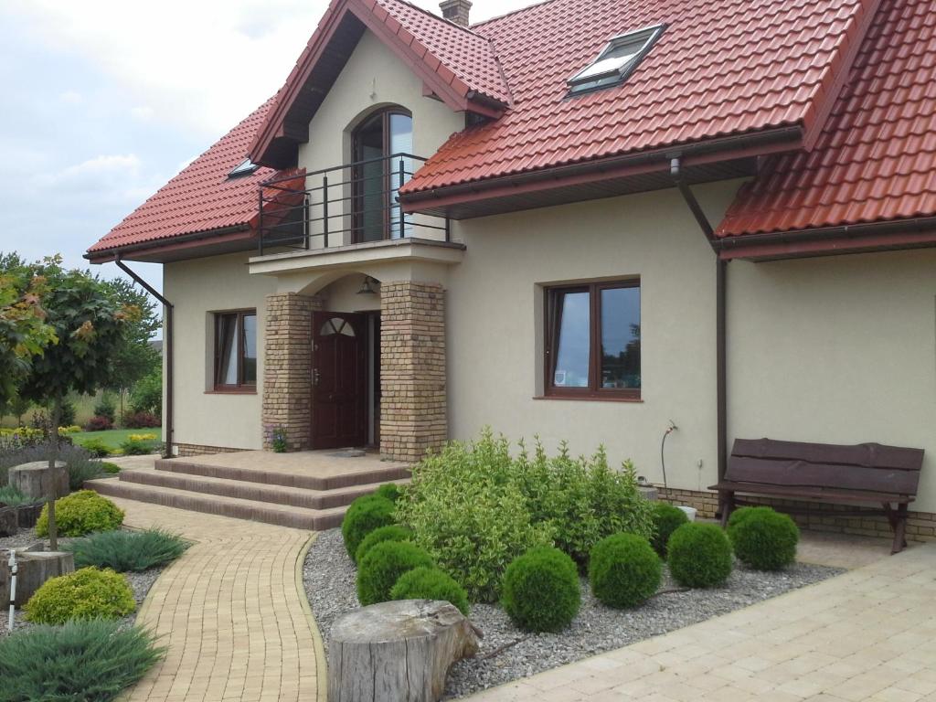 ein Haus mit rotem Dach und Gehweg in der Unterkunft Dom przy Kociej Górze in Krzczeń