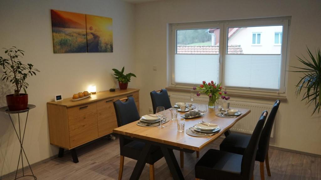 a dining room with a wooden table and chairs at Ferienwohnung Renke in Alberode
