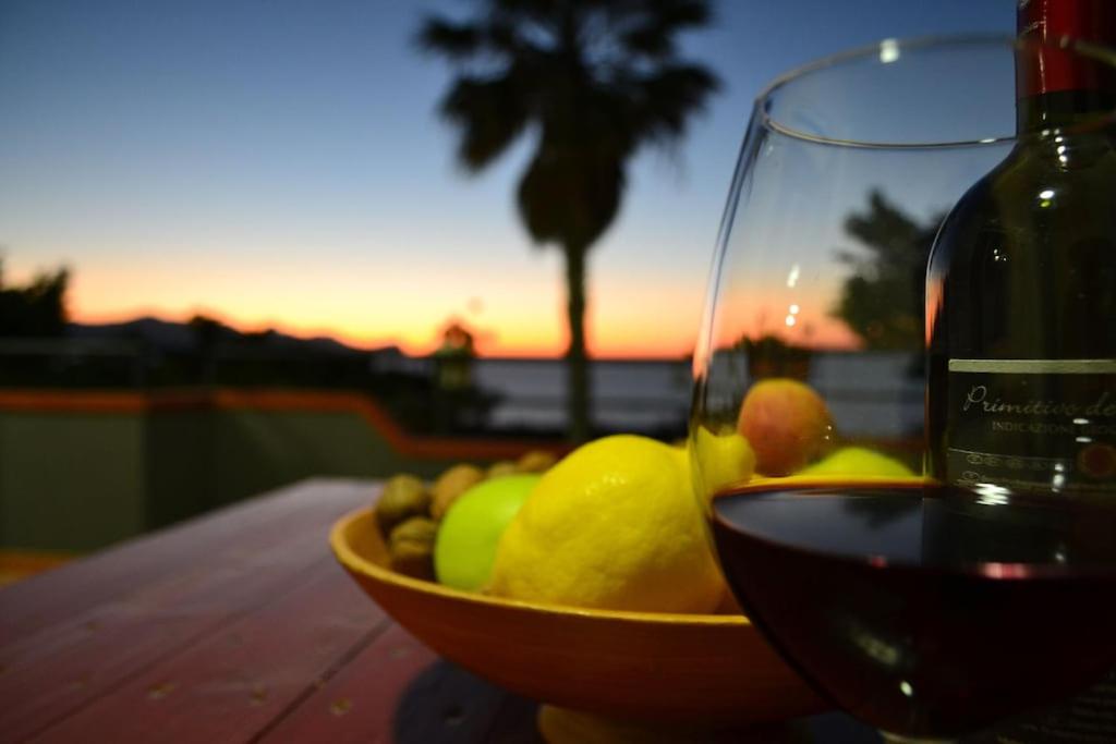 uma taça de fruta e um copo de vinho numa mesa em Maison Bellevue em Alcamo Marina