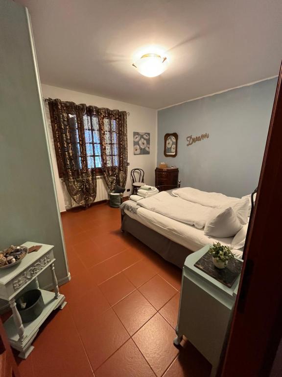 a bedroom with a bed and a table and a window at Rocca di Corno Guest House in Finale Ligure