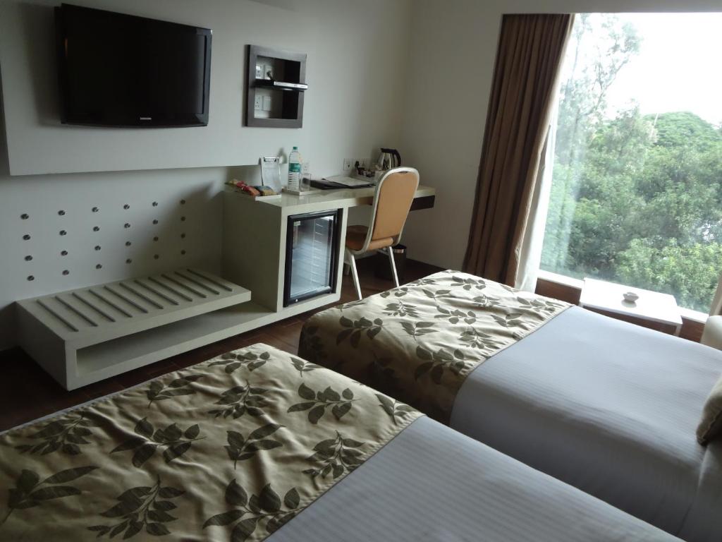 Postel nebo postele na pokoji v ubytování Ramee Grand Hotel and Spa, Pune