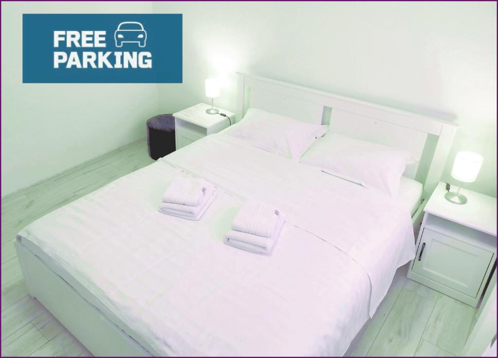 ein Schlafzimmer mit einem weißen Bett mit zwei Handtüchern darauf in der Unterkunft Smart Apartament in Piatra Neamţ