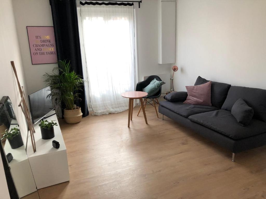 een woonkamer met een bank en een tafel bij Le Spot, appartement spacieux à 30m de la mer 45m2 in Luc-sur-Mer