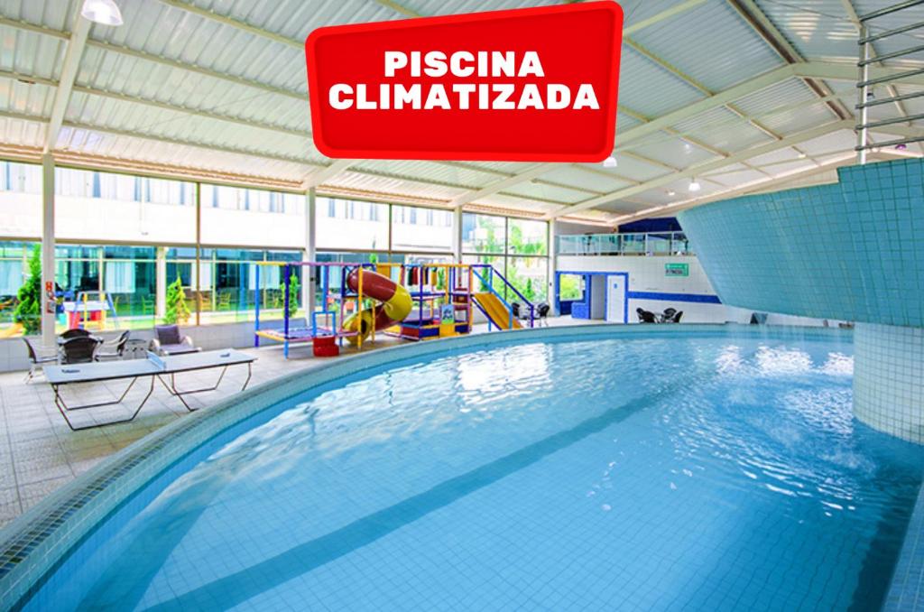 a swimming pool in a building with a sign at Hotel Golden Park Sorocaba & Convenções - by Nacional Inn in Sorocaba