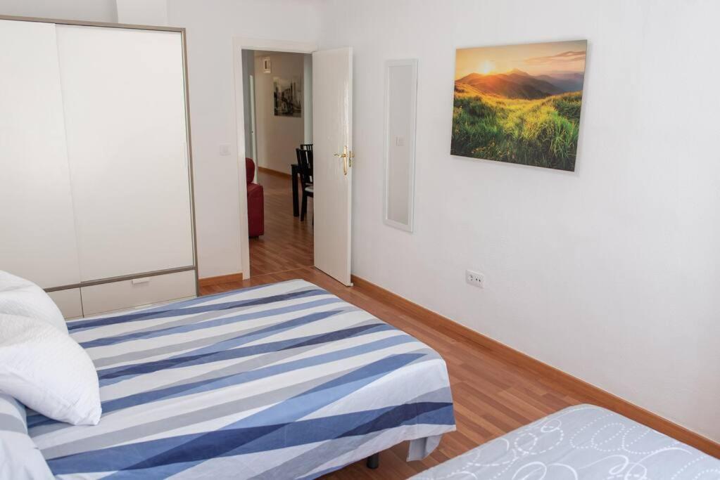 una camera da letto con un letto e un dipinto sul muro di Apartamento Alexa, a 800mts Catedral WiFi Smart TV a Murcia
