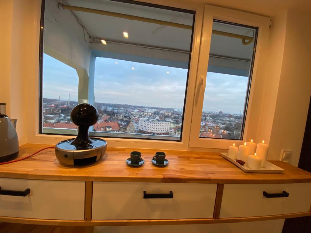 a kitchen counter with a large window with candles at Apartament B122 z widokiem na morze in Gdańsk