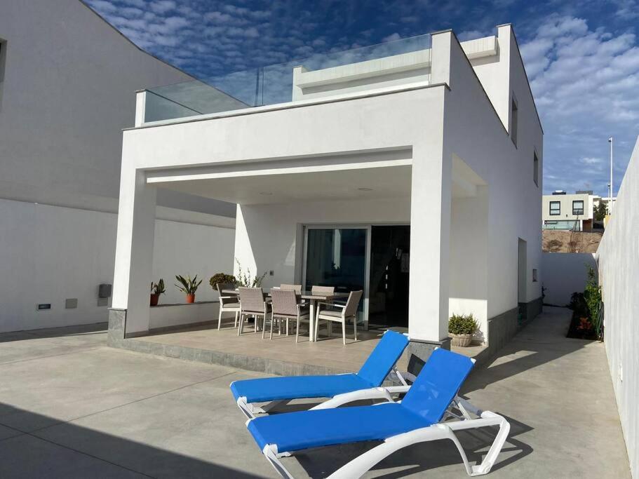 para niebieskich krzeseł siedzących na patio w obiekcie Casa de Playa maravillosa en Taliarte w mieście Las Palmas de Gran Canaria