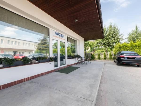 a dealership with a car parked in a parking lot at Pokoje Tanie Spanie in Zator
