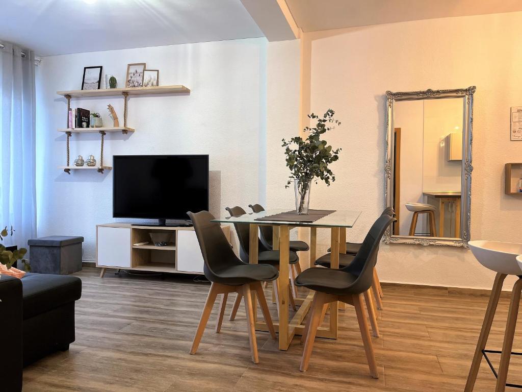 a living room with a table with chairs and a television at Apartamento Córdoba Palace in Córdoba