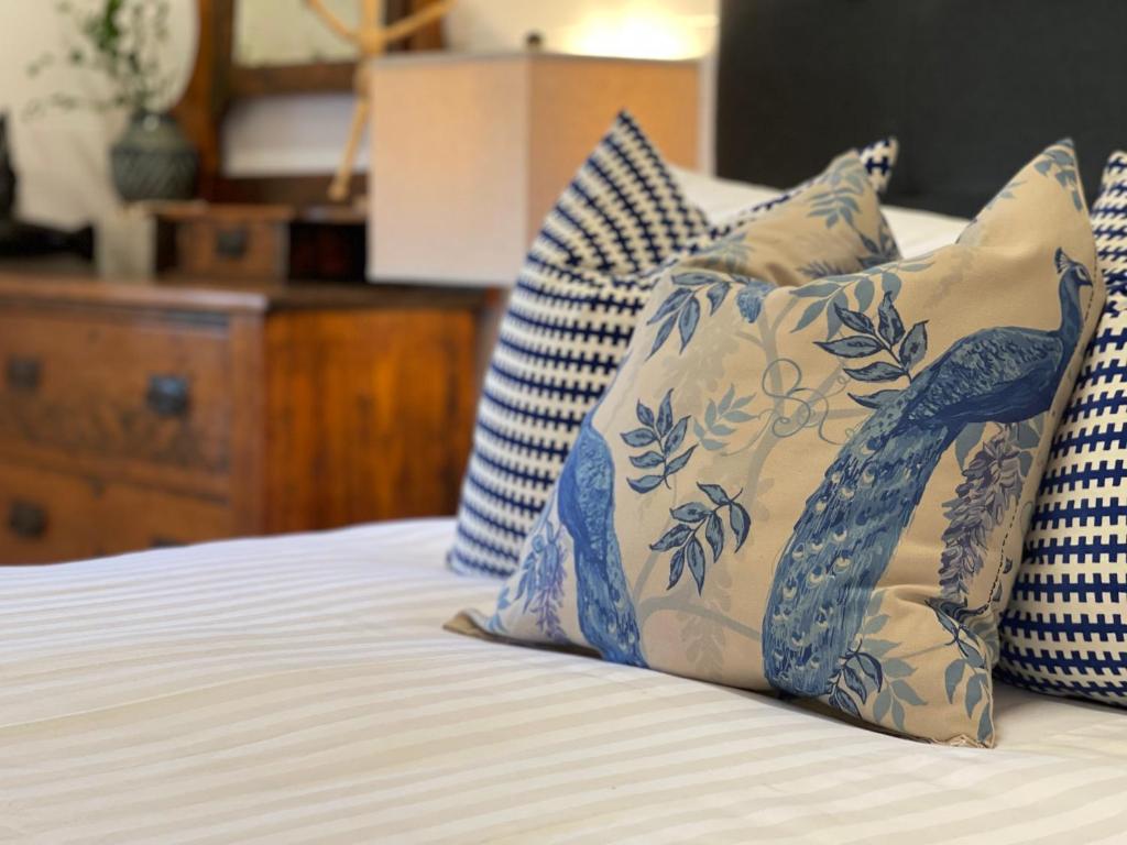 a bed with blue and white pillows on it at The Residence Stylish Comfort with Fireplace in Tenterfield