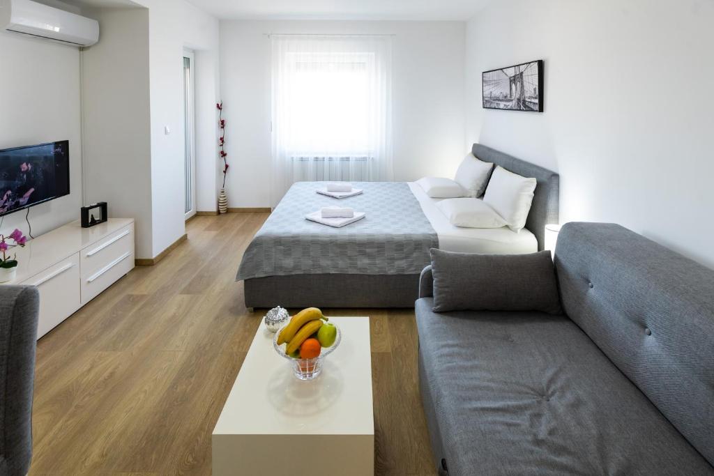 a living room with a bed and a couch at MB Apartment 2 in Subotica