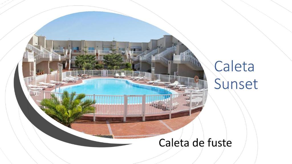 vista sulla piscina in un resort con le parole calico sunset di Caleta Sunset a Caleta De Fuste