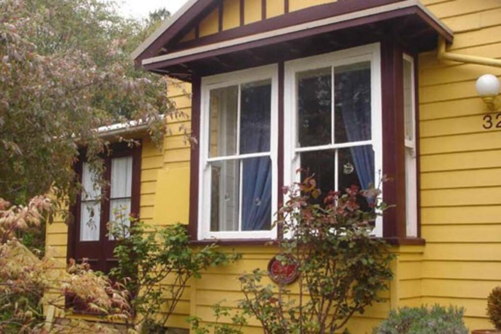 a yellow house with a window on the side of it at Dowling Cottage - tranquil haven in Blackheath in Blackheath
