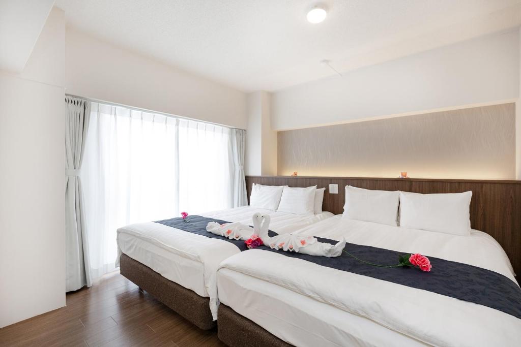 twee bedden in een hotelkamer met bloemen erop bij Ideal Fukushima in Osaka