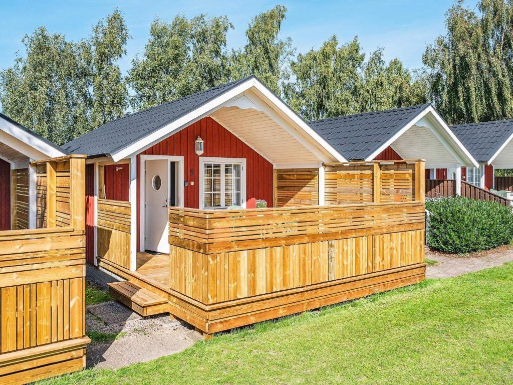 Löttorp的住宿－Holiday home LÖTTORP XII，一座带木甲板和围栏的房子