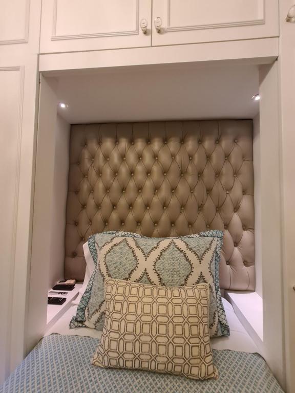 a bed with a brown padded headboard in a bedroom at Avenida Las Heraas in Buenos Aires