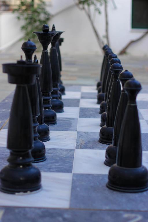 a chess board with black chess pieces on it at Kalidon Panorama Hotel in Kokkari