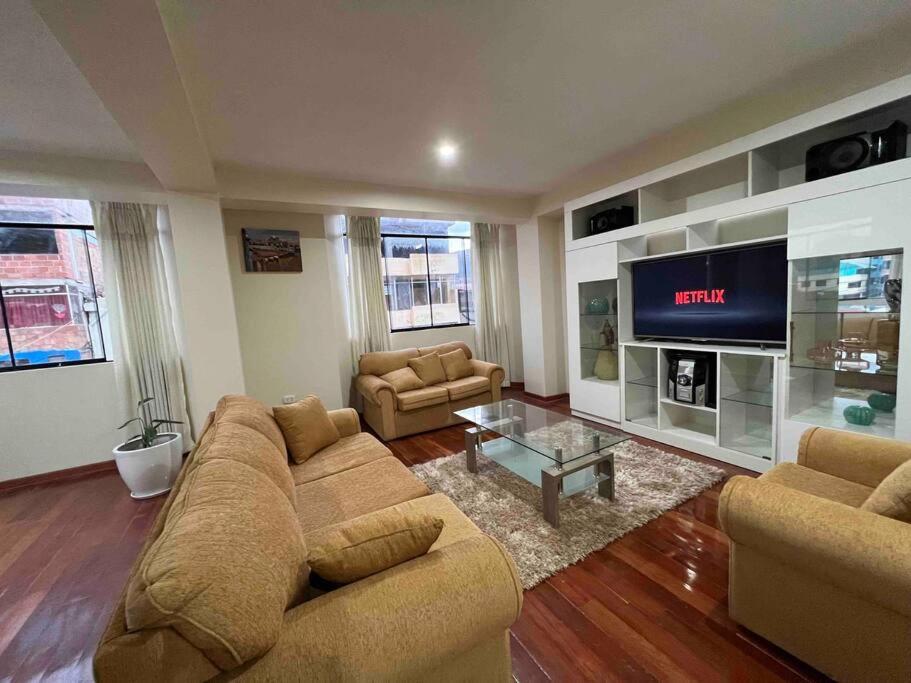 a living room with a couch and a tv at Apartamento exclusivo en Cusco cerca al aeropuerto in Cusco