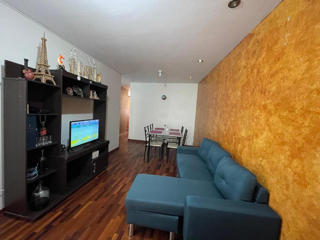 特魯希略的住宿－Exclusivo Apartamento en el corazón de Trujillo，客厅配有蓝色的沙发和桌子