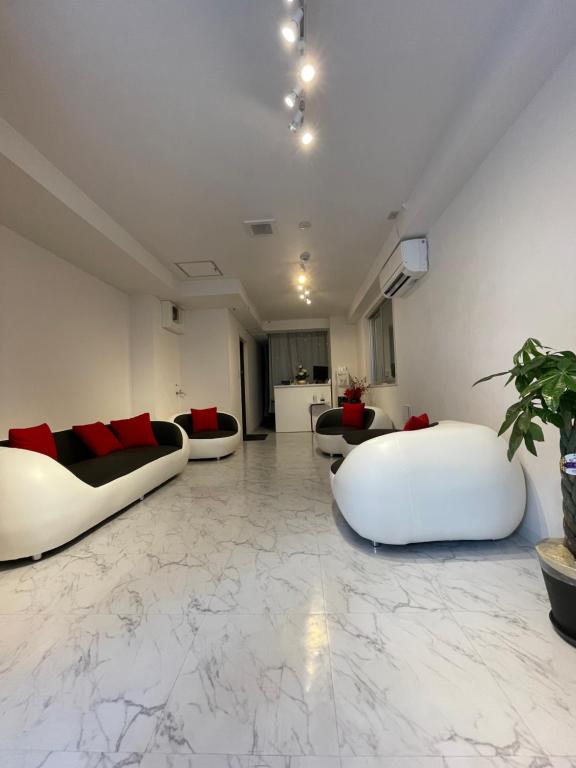 un soggiorno con 2 divani bianchi su un pavimento in marmo di HotelHarmony日暮里ホテルハーモニー a Tokyo