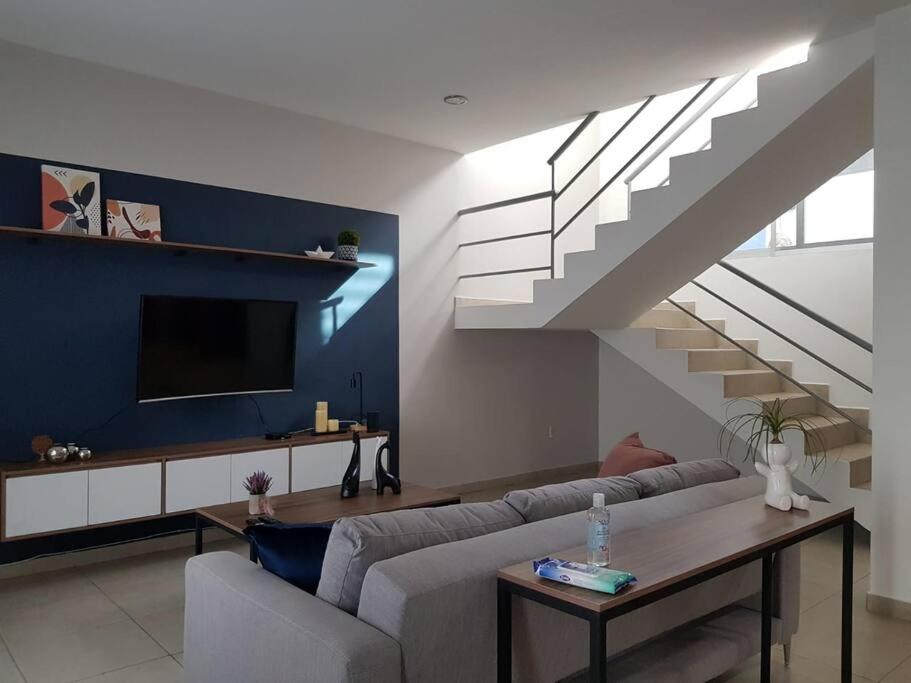 a living room with a couch and a staircase at CASA Azul Turquesa Excelente Ubicacion Facturamos in Guadalajara