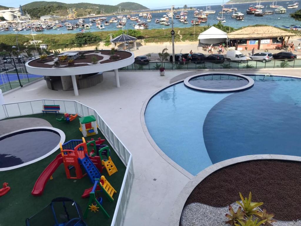 uma vista superior de uma piscina num resort em Ap Anjos de Arraial - Residencial de frente para a Praia dos Anjos - Arraial do Cabo em Arraial do Cabo