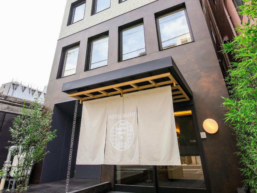 a building with a sign on the front of it at Hotel Muso in Kyoto