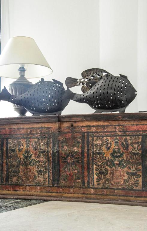 two sculptures on top of a wooden table with a lamp at Kalidon Panorama Hotel in Kokkari