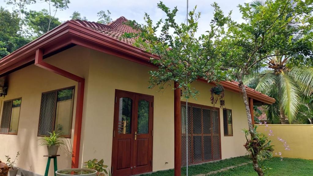 韋利格默的住宿－El-Nivasa Villa in Weligama，红色屋顶的黄色小房子