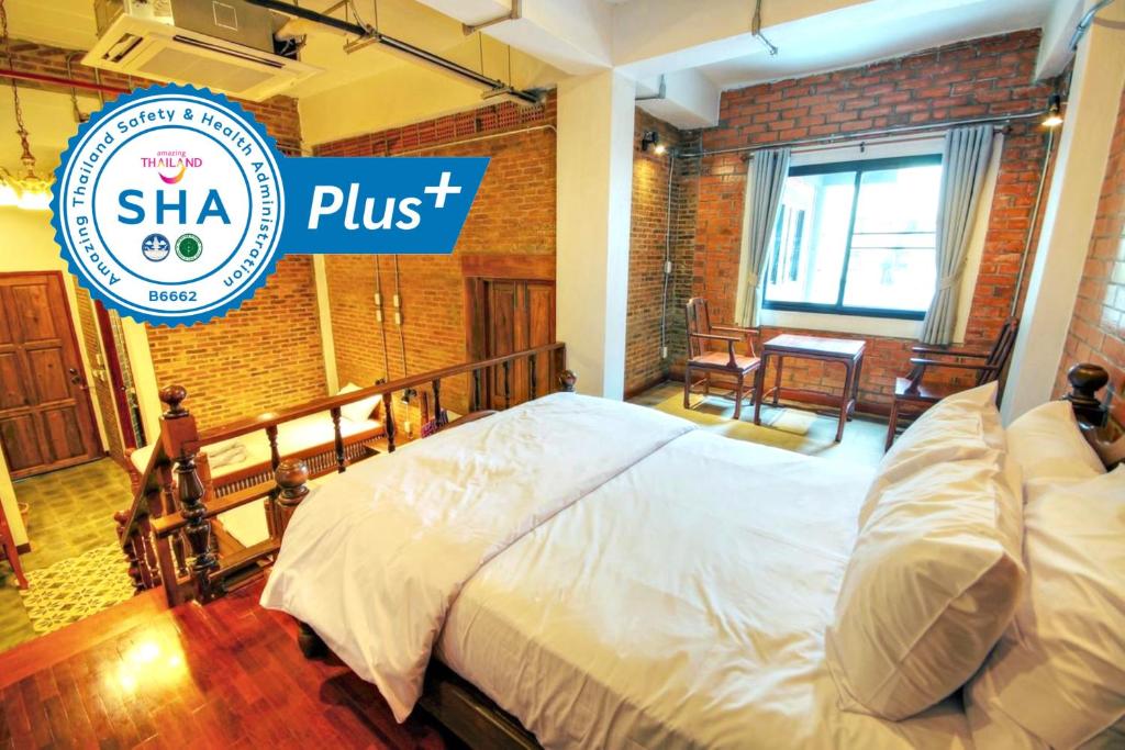 um quarto com uma cama com uma placa que diz shka plus em Saeng Panya Home SHA Plus em Chiang Mai