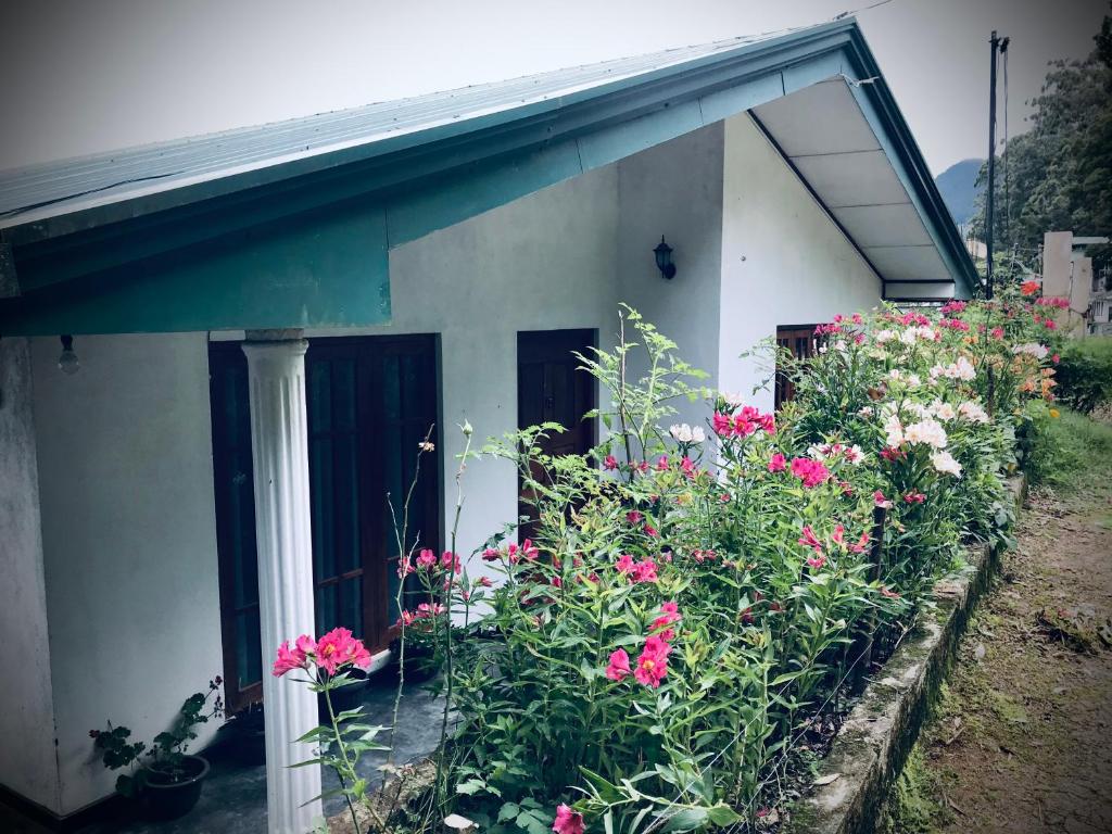 ein weißes Haus mit Blumen davor in der Unterkunft B&B Nuwara eliya in Nuwara Eliya