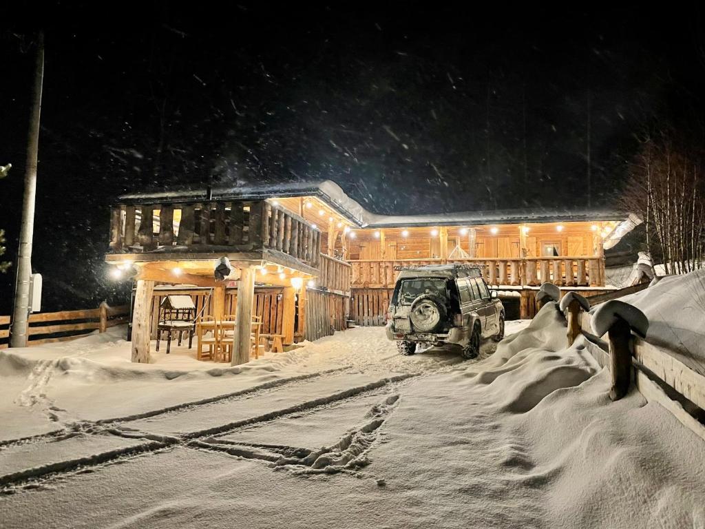 a jeep parked in the snow in front of a building at Bacovka Szlembark- jacuzzi, kominek, widok na Tatry in Szlembark