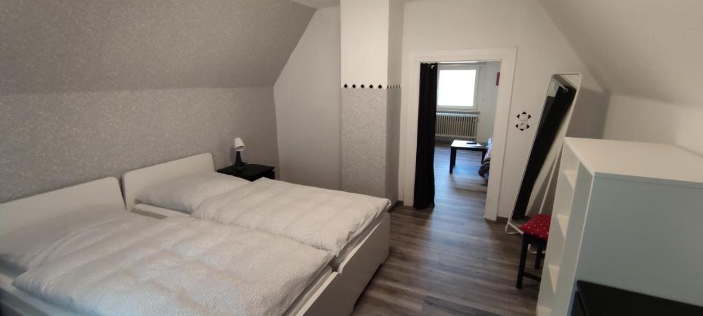 ein Schlafzimmer mit einem weißen Bett in einem Zimmer in der Unterkunft Haus Kunterbunt in Mehlingen