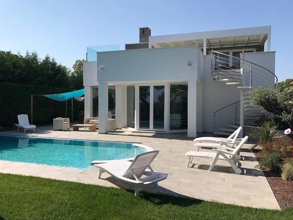 a villa with a swimming pool and a house at Super Villa With Private Pool in Isola Albarella in Isola Albarella