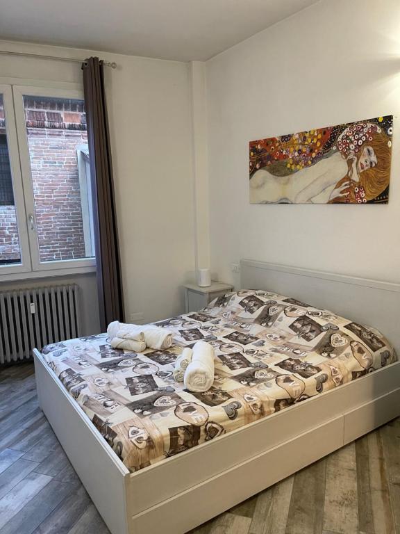 Bett in einem Schlafzimmer mit Wandgemälde in der Unterkunft BONBON in Rovigo