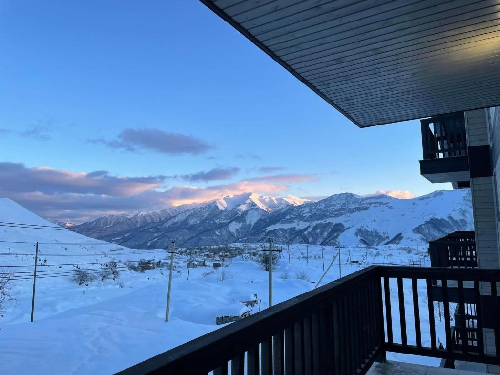 a view of a snow covered mountain from a balcony at Apartment Qumli in Gudauri