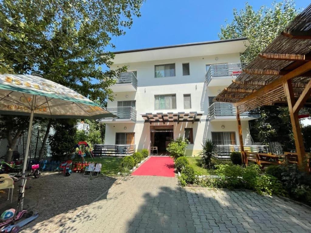 a building with a red carpet in front of it at Aparthotel Vila Tufi in Velipojë