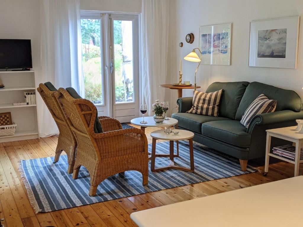 a living room with a green couch and chairs at Haus Hygge in Holm