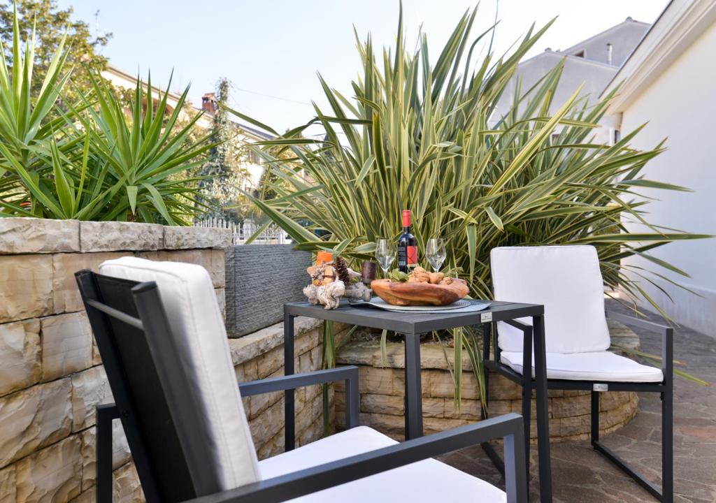 a table and chairs on a patio with plants at Apartments Leona in Umag