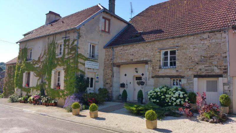 een stenen gebouw met bloemen ervoor bij La Vallée Verte in Grandchamp