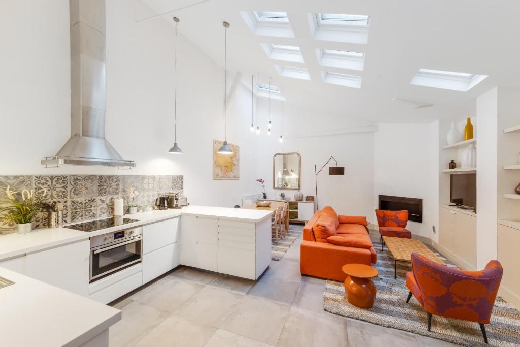 Il comprend une cuisine ouverte et un salon avec un canapé orange. dans l'établissement Les appartements de l'atelier paris 15, à Paris