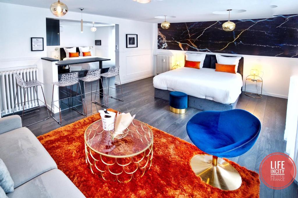 ストラスブールにあるLİFE İNCİTY - Petite France By Life Renaissanceのベッド、テーブル、ソファが備わるホテルルームです。