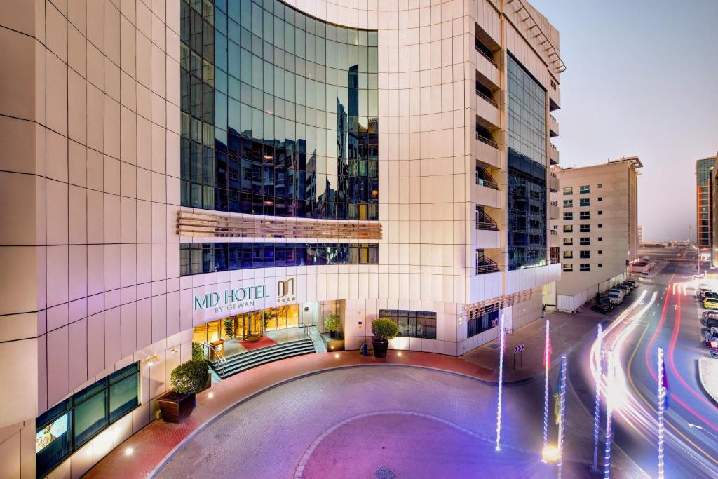 MD Hotel By Gewan في دبي: مبنى كبير أمامه مسبح