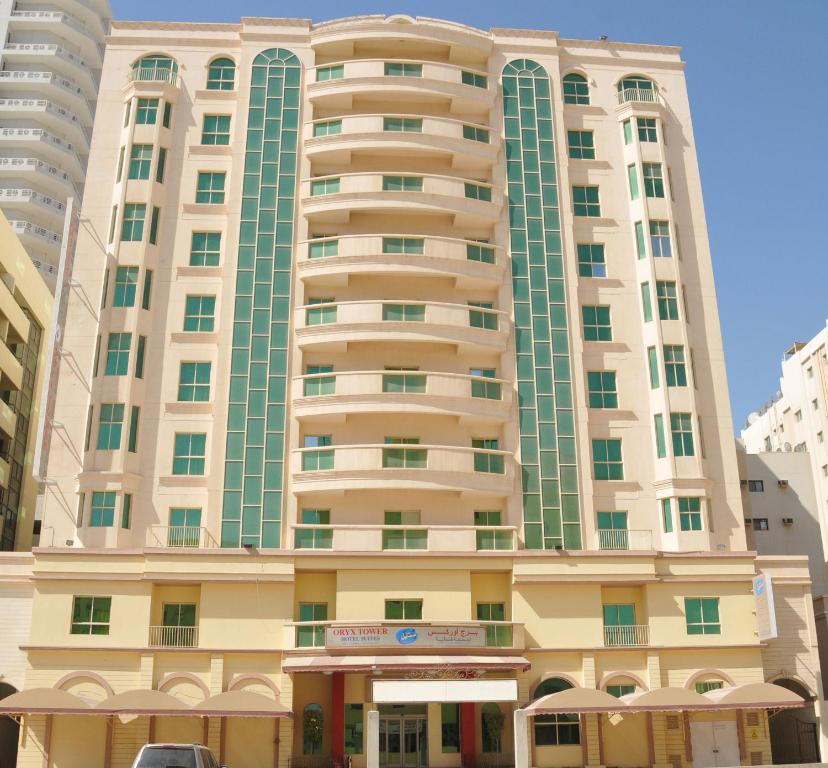 a large tall building with a car parked in front of it at Oryx Tower in Manama