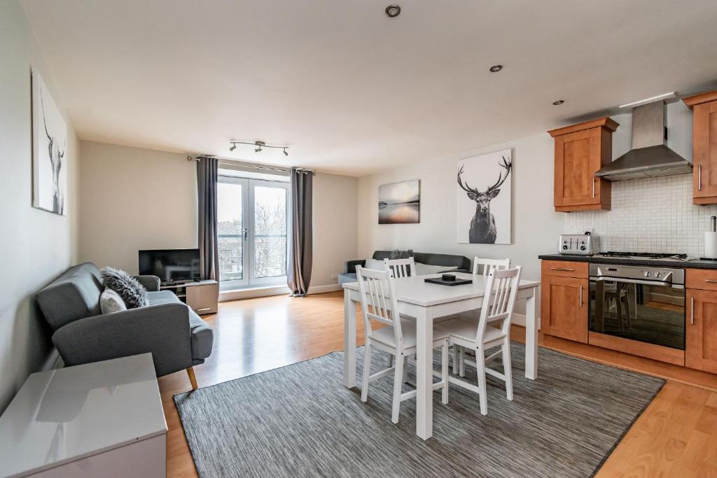 a kitchen and living room with a white table and chairs at amazing apartments - Cables Wynd near The Shore - Free Parking in Edinburgh