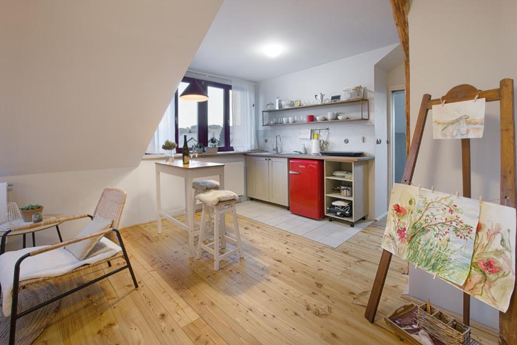 Habitación con cocina con mesa y pintura en Apartmány v domečku, en Hlinsko
