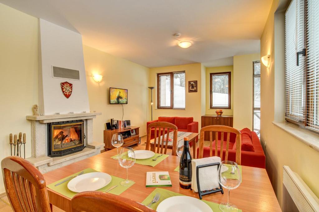 une salle à manger avec une table et une cheminée dans l'établissement *By the Fireplace* Cosy 1BD Flat with a nice view, à Pamporovo